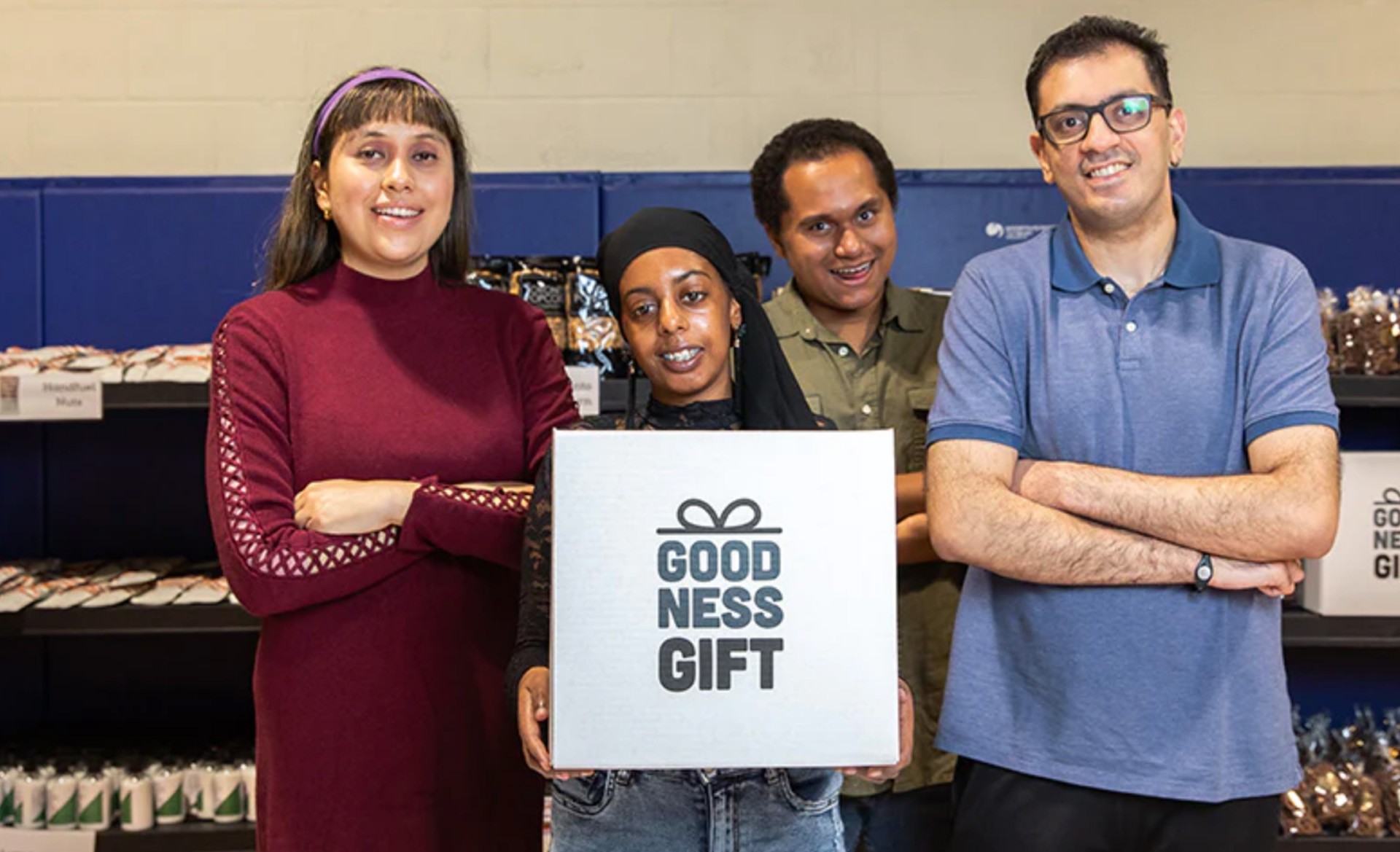 A group of 4 workers from the Goodness Gift social enterprise holding a gift box and smiling